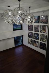 Habitación con lámpara de araña y cuadros en la pared. en At Sakon Hotel, en Sakon Nakhon
