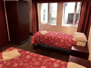 a hotel room with two beds and a window at Four Stars Hotel in London