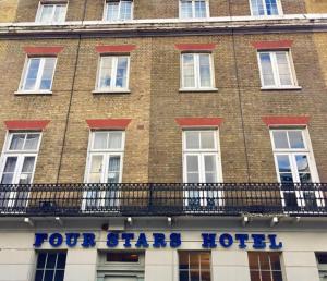 a tall brick building with a sign for four star hotel at Four Stars Hotel in London