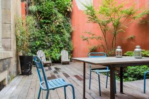 Une table et des chaises en bois sont disponibles sur la terrasse. dans l'établissement Authentic Flat in Dijon, à Dijon