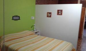 1 dormitorio con 1 cama y TV en la pared en Casa de Silvia en Villa Carlos Paz