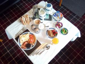 a white table with breakfast foods and drinks on it at Palace Hotel - Small Hotel in Oban