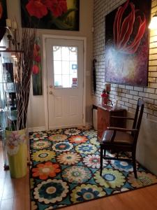 um quarto com uma mesa e uma porta com um tapete de flores em Atelier Galerie Anne Drouin Peinture & Pension em Sainte-Julie