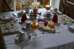 einen Tisch mit einem weißen Tischtuch mit Speisen und Getränken in der Unterkunft Guaire House Killarney in Killarney