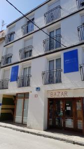 a white building with abaar on the side of it at Apartments Mar de Tossa in Tossa de Mar