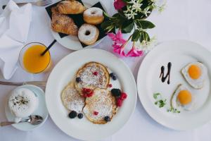 a table with plates of breakfast foods and drinks at Park Hotel Ermitage Resort & Spa in Lido di Jesolo