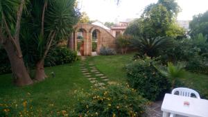a garden with a stone path leading to a building at Residence Il Giunco in Presicce