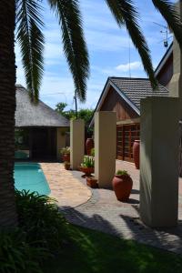 a backyard with a swimming pool and a house at Castello Guesthouse Vryburg in Vryburg