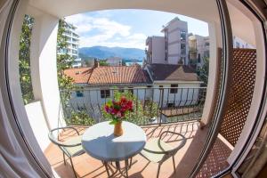 a balcony with a table and chairs and a vase of flowers at Apartments Luka in Budva
