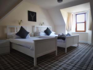 a bedroom with two beds and a window at Kilchoan Hotel in Kilchoan