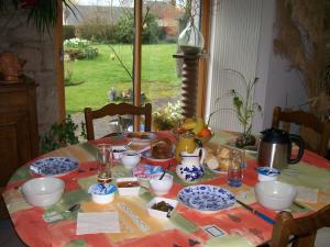 Les Rhodos في Noirpalu: طاولة عليها صحون زرقاء وبيضاء