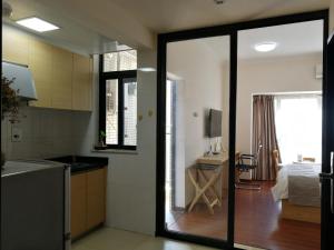 a kitchen with a sliding glass door leading to a bedroom at Guangzhou Convention Center Apartment in Guangzhou