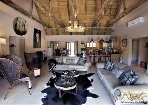 una gran sala de estar con sofás y una mesa. en Luvivane Luxury Villa & Cottage en Marloth Park