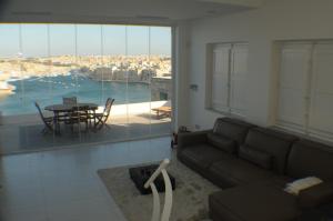 a living room with a couch and a table at Valletta Dream Penthouse in Valletta
