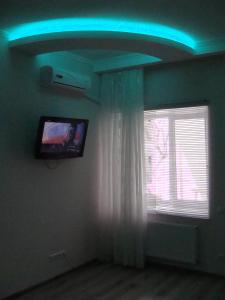 a room with a blue ceiling with a tv and a window at Hotel Lidia in Chişinău