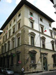 ein großes weißes Gebäude mit Flaggen darüber in der Unterkunft Crystal Suite in Florenz