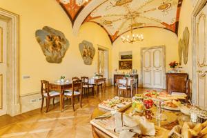 uma sala de jantar com mesas e cadeiras e um tecto em Relais degli Angeli Residenza d'Epoca em Siena
