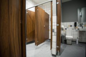ein Badezimmer mit einem WC und einer Holztür in der Unterkunft PubLove @ The Crown, Battersea in London