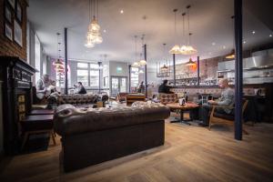 a room with couches and people sitting in a restaurant at PubLove @ The Crown, Battersea in London