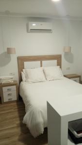 コルドバにあるLuxury Viana Apartmentsのベッドルーム(白いベッド1台、テーブル付)