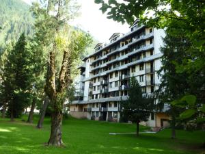 a large apartment building in a park with trees at Apartment Chamois Blanc 1 in Chamonix-Mont-Blanc