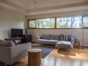 een woonkamer met een bank en een tv bij Freycinet Studios "Nook" in Coles Bay