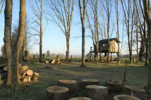 una foresta con tronchi e una casa sull'albero sullo sfondo di Les Rhodos a Noirpalu