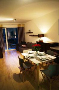 Una sala de estar con una mesa y sillas blancas. en DWIE SOSNY Apartament 52, en Ustronie Morskie