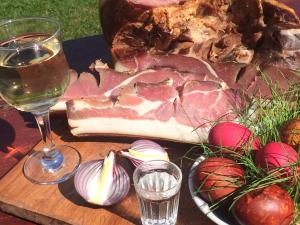 una mesa con un trozo de carne y una copa de vino en Bodrogeni Căsuțe, en Poiana Aiudului