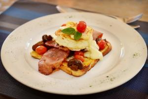 a white plate with breakfast food on a table at Scott's Manor Guesthouse Function and Conference Venue in Lichtenburg