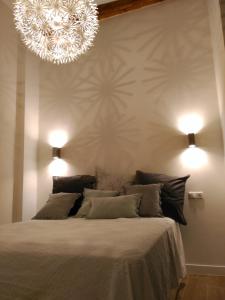 - une chambre avec un grand lit et un lustre dans l'établissement Luxury Catedral, à Malaga