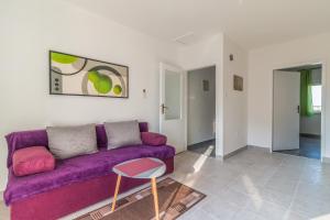 a living room with a purple couch and a table at Apartment Buic in Pula
