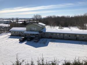 a house in the snow with two cars parked at New Country Motel in Swan River