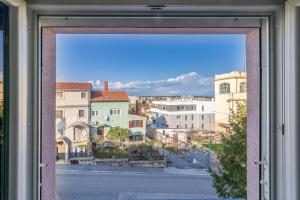 Blick auf eine Stadt durch ein Fenster in der Unterkunft Apartment Buic in Pula