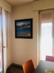 a painting hanging on a wall with a table and chairs at Cabà Holiday Bardolino D'Annunzio in Bardolino