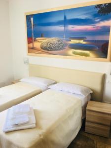 dwa łóżka w pokoju z obrazem na ścianie w obiekcie Cabà Holiday Bardolino D'Annunzio w mieście Bardolino