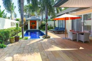 a patio with a pool and a table and an umbrella at 5 Islands Beach Villa @ Lipa Noi in Lipa Noi