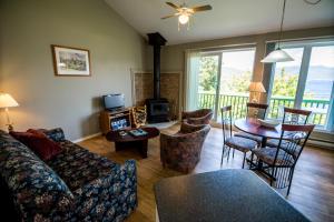 een woonkamer met een bank en een tafel bij Chalets Condos sur le Fjord in LʼAnse-Saint-Jean