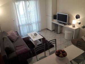 uma sala de estar com um sofá e uma mesa com uma televisão em Apartments Ane em Sukošan
