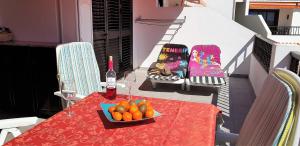 a table with a bottle of wine and a bowl of oranges at Ocean view sunny apt at Ocean Park in Adeje