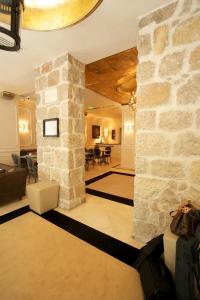 a lobby with a stone wall and a living room at Hotel De Monaco in Cap d'Ail