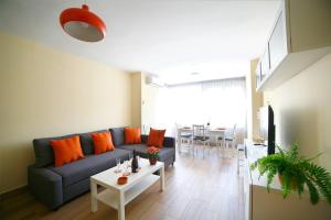 マラガにあるApartamento con parking Unión 45のリビングルーム(青いソファ、オレンジの枕付)