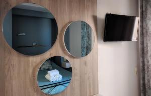 Zimmer mit 2 Spiegeln und einem TV in der Unterkunft Levante Sea View Studios in Stalida