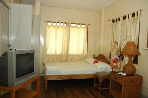 Cette petite chambre comprend un lit et une télévision. dans l'établissement Masamayor's Beach House and Resort, à Îles Camotes
