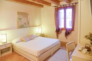 a bedroom with a bed and a window at Agriturismo Monte degli Aromi in Villaga