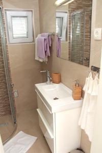 a bathroom with a sink and a shower and a mirror at Lari Home in Primošten