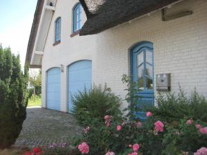 a house with two blue garage doors on it at Ferienhaus Uhlenhorst in Büsumer Deichhausen