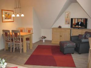 a living room with a dining table and a tv at Ferienhaus Uhlenhorst in Büsumer Deichhausen
