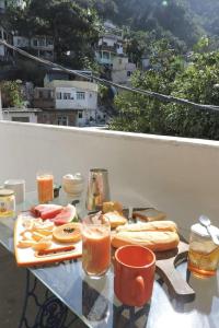 einen Tisch mit einem Tablett mit Speisen und Getränken auf dem Balkon in der Unterkunft Natural Do Rio Guesthouse in Rio de Janeiro + 65 Fotos