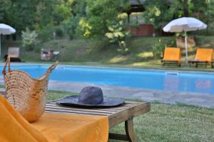 um chapéu sentado numa mesa ao lado de uma piscina em Villa Marina em Terranuova Bracciolini